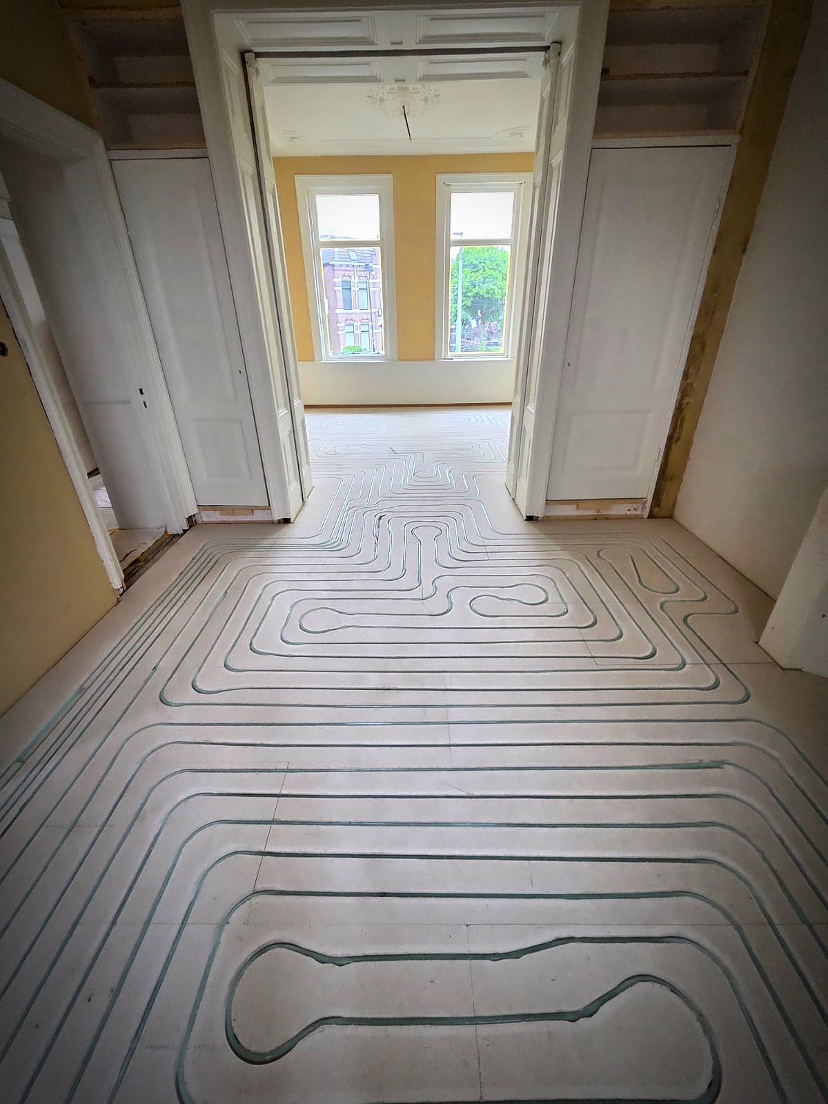 Ingefreesde leidingen in een Fermacell-droogbouwvloer door meerdere kamers